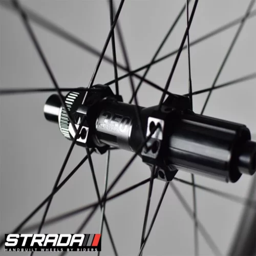 A close up of a black DT Swiss 350 bicycle hub laced to a Strada Performance Aero Disc 55 Ultra wheel using black spokes.