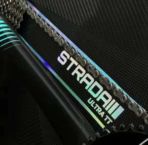 A picture showing a carbon Strada Ultra TT Disc Disc Brake rear wheel in a raw carbon finish with a custom Hollowgraphic Strada Ultra TT logo.